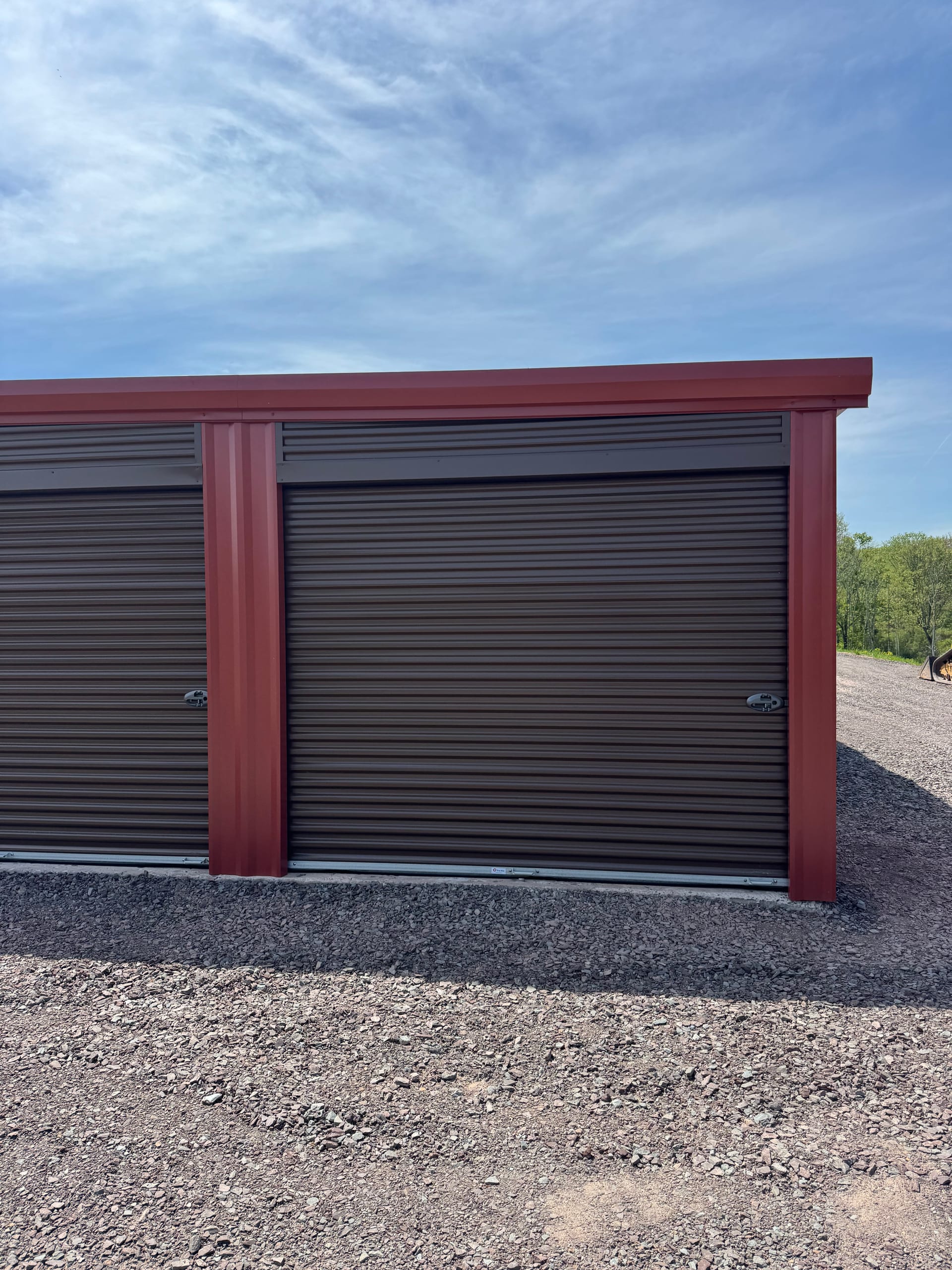 Close-up of a red drive-up storage unit with a roll-up door at Greystone Storage of Sweet Valley